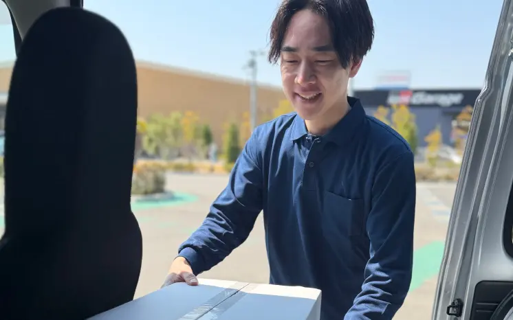 軽バンから荷物を降ろす軽貨物ドライバー