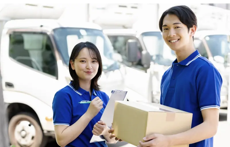 笑顔で並ぶ男女の軽貨物ドライバー